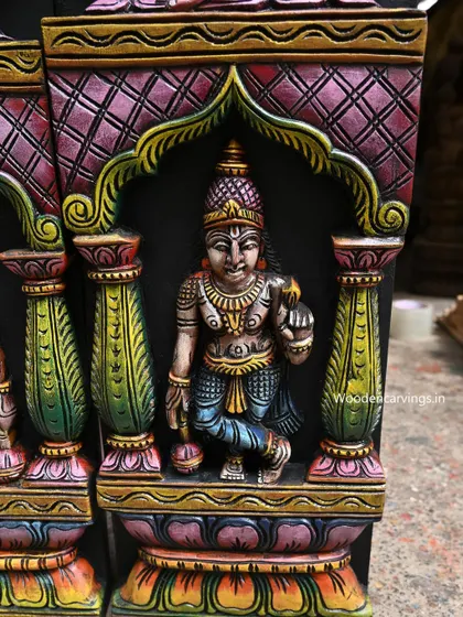 A close-up of one of the lower figures on the Astalakshmi panel, showing the detailed architecture of the carved niche.