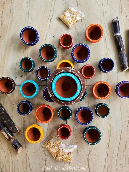 A top-down view of the painted pots, sugarcane, and grains before I created the final festive arrangement. I love the bright colors on the rims of the pots.
