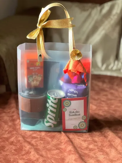 This Rakhi gift bag includes a mix of snacks, a drink, and other items, making it a simple yet complete gift for a brother.