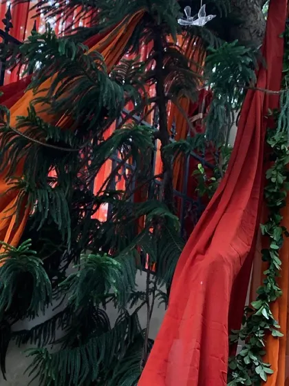 A vibrant mix of red and orange drapes intertwined with natural pine branches. This combination of colors and textures is perfect for creating a rustic, autumnal feel.