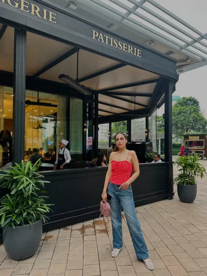 A full-length shot of the red top and jeans outfit.