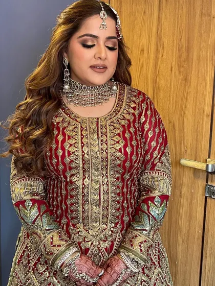 A reception-ready look with soft curls and a beautiful red and gold outfit.