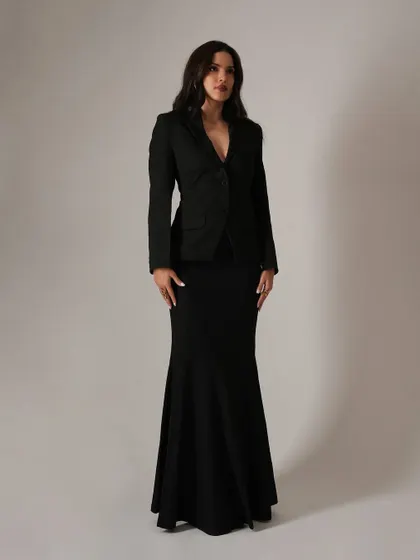 A clean, full-length shot that showcases the elegant and statuesque silhouette of the black blazer and mermaid skirt combination. This is a perfect example of timeless event styling.