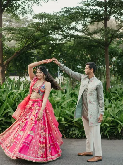 A groom gives his bride a sweet kiss on the cheek as they dance together during their Mehendi or Sangeet party.