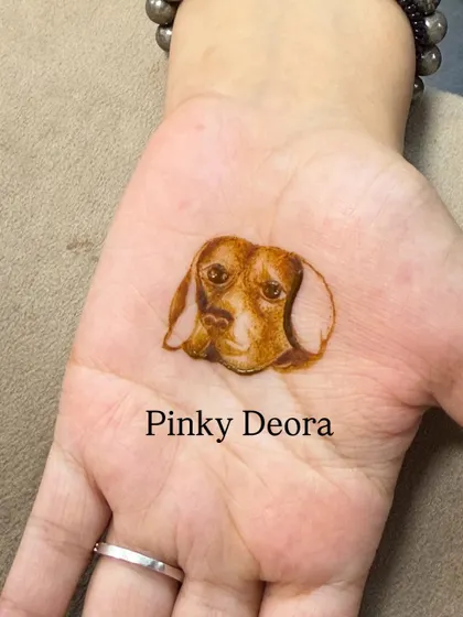 A minimalist portrait of a dog's face on the palm. Even with just a few strokes, the love and personality of the pet shine through.