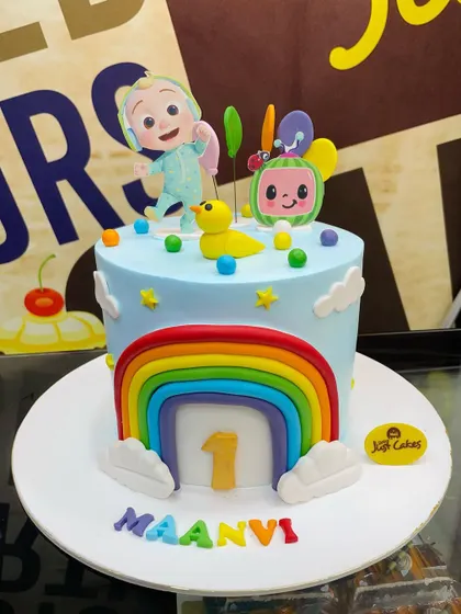 A bright and happy 2.5kg Cocomelon cake with a rainbow arch for a first birthday celebration.
