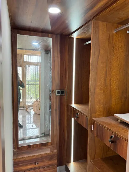 A glimpse inside a walk-in closet. We used warm wood laminate and integrated vertical lighting to create a luxurious, boutique-like feel.