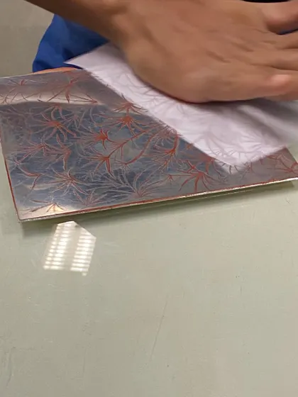 Inking a metal plate before printing. The choice of color and the way the ink is applied can dramatically change the character of the final print, offering endless possibilities for exploration.