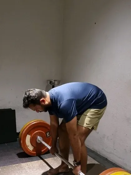 A client at the bottom of a deadlift, demonstrating the starting position for a powerful pull.