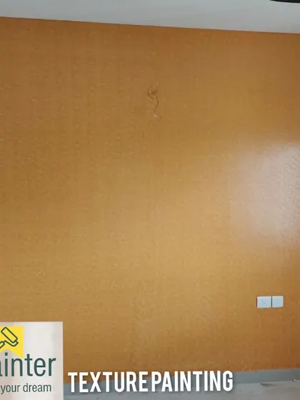 A mustard-yellow wall with a fine, uniform texture. This is a great way to add depth to a solid color, making it more dynamic than a simple flat paint.