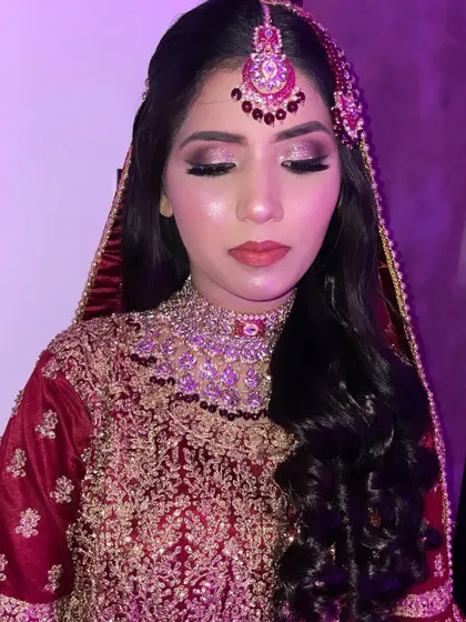 A close-up under purple lighting. This shows how the glittery eye makeup catches the light, creating a dramatic and glamorous effect.