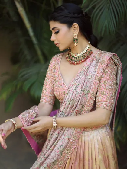 This beautiful pink lehenga is styled with a navratna-style choker, making it a perfect outfit for a festival like Navaratri or for a pre-wedding event.