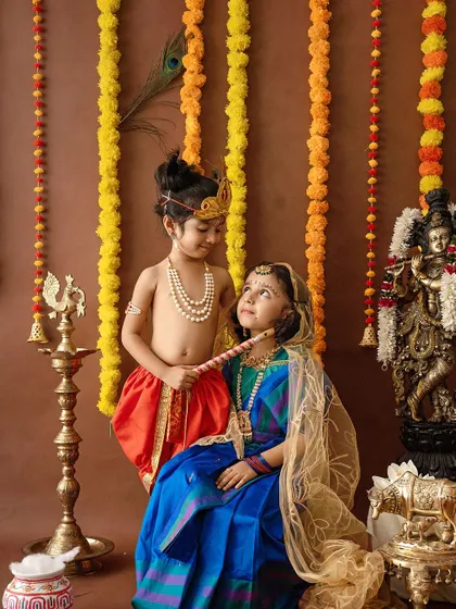A sweet interaction between two children dressed as Radha and Krishna.