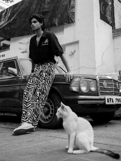 An unposed moment during an urban fashion shoot, where a cat wandered into the frame. This adds a touch of spontaneity and story to the editorial shot.