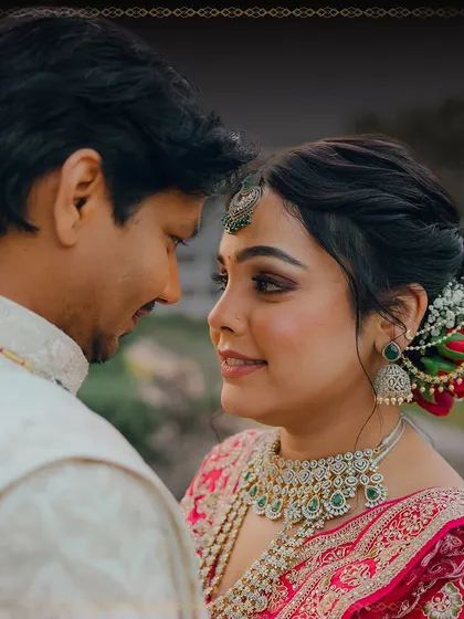 A close-up of the couple, capturing a moment of connection. The bride's makeup is flawless, with beautifully defined eyes that stand out.