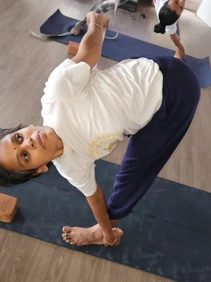 A student holds a bound revolved triangle pose, a testament to the strength and flexibility gained through the disciplined practice in our TTC.