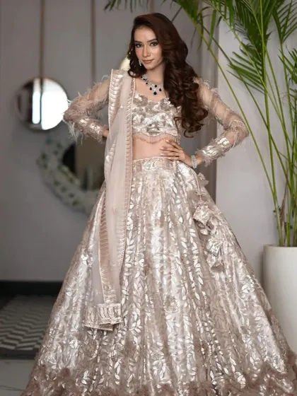 A full-length view of the champagne-gold lehenga-gown, showcasing its unique texture and elegant silhouette.