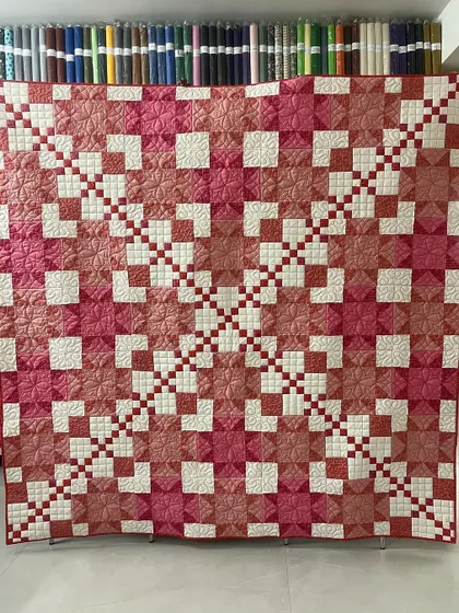This lovely quilt combines two classic patterns: the Star and the Irish Chain. The shades of pink and rose give it a romantic, monochromatic look.