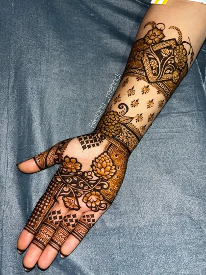 A gorgeous floral design that extends up the arm. The use of negative space with scattered motifs on the forearm contrasts beautifully with the denser patterns on the palm.