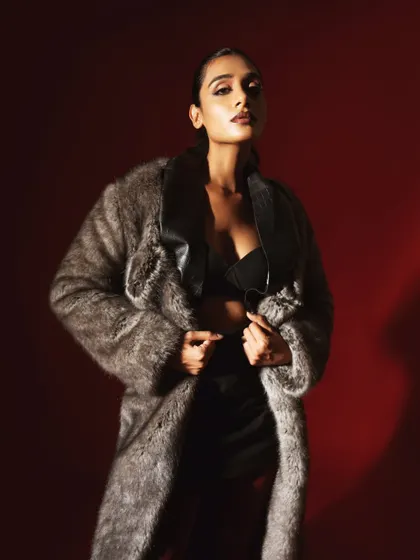 A confident and stylish full-look shot. The combination of the faux fur, leather, and strong pose creates a modern and edgy fashion statement.
