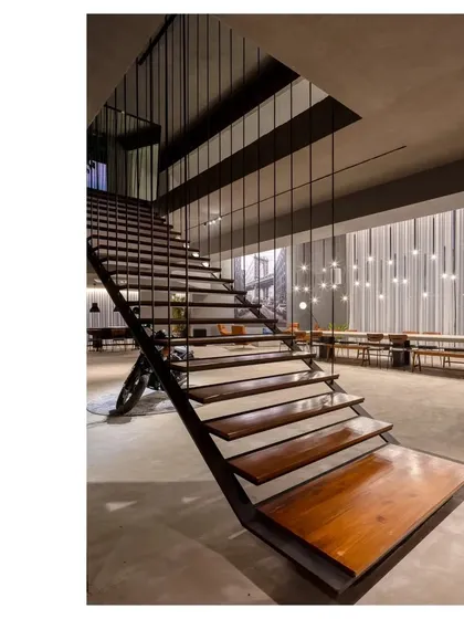 The suspended staircase in our elemental gallery space. The design uses a mix of wood, steel, and concrete to create a modern, industrial feel that is both raw and refined.