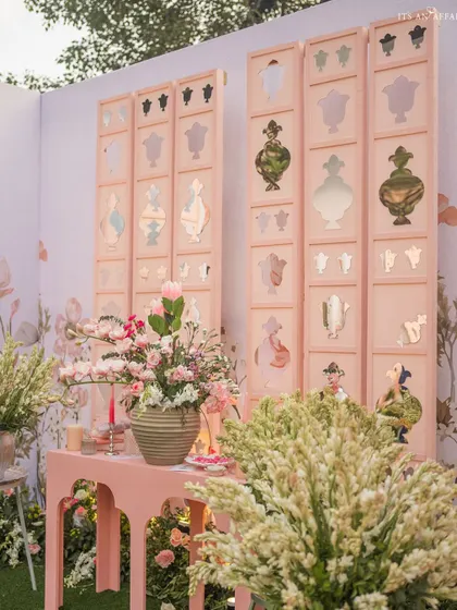 Custom-made screens with perfume bottle cutouts and mirror details serve as a unique and artistic backdrop.