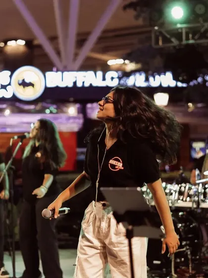 A candid moment of pure joy while performing outdoors. This photo perfectly captures the fun and free-spirited energy of a Moksha All Stars show.