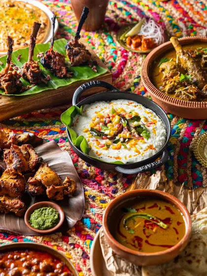A colorful and festive spread of modern Indian cuisine. We use rich textures and props to create a visually dense image that reflects the complexity of the flavors.