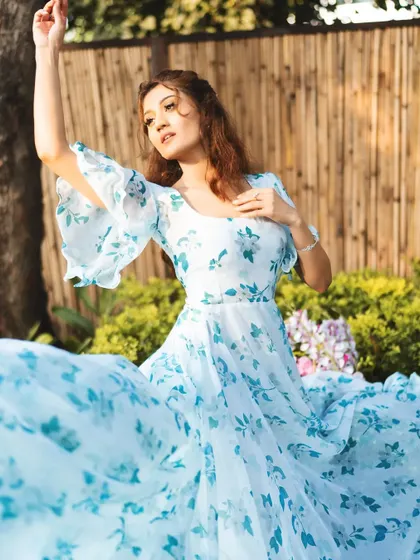 A dynamic shot from the same outdoor session, capturing the movement of the flowing floral gown. This creates a sense of freedom and elegance.