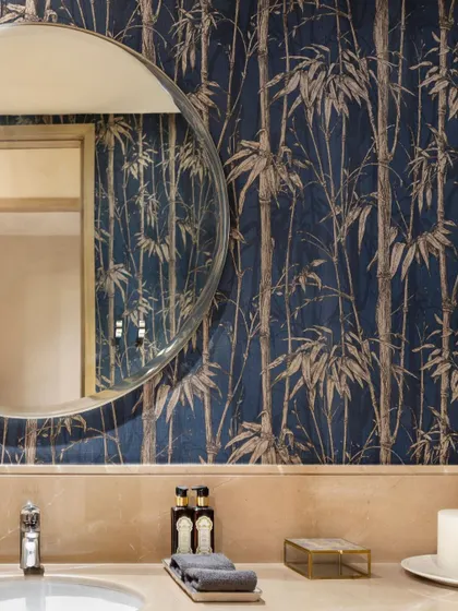 A powder room featuring a striking bamboo-patterned wallpaper and a simple, modern vanity. This shows our attention to detail in even the smallest spaces, using texture and pattern to create impact.
