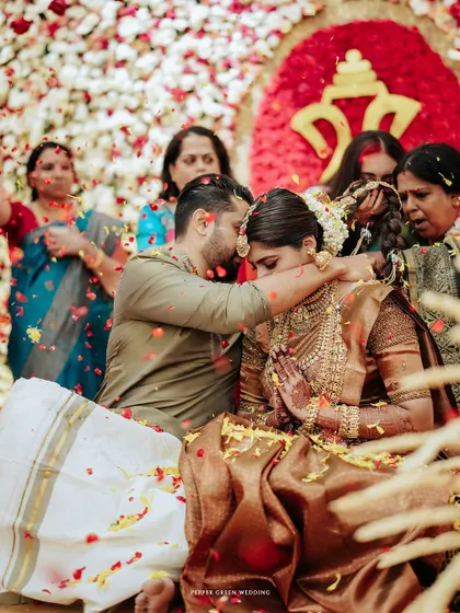 In a shower of fragrant petals, Sradha and Vinay share a sacred moment during their Hindu wedding ceremony. Capturing the pure joy and traditional blessings is what makes a wedding film truly timeless.