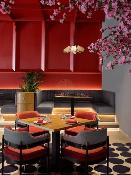 An intimate dining nook at Foo, where the red paneled walls and focused lighting create a cozy corner perfect for small groups.