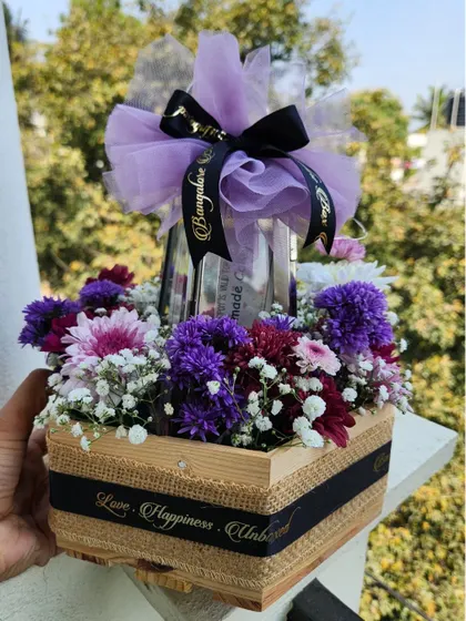 Love is a promise that can last forever. This Promise Day hamper features love coupons nestled in a garden of fresh purple flowers, all beautifully arranged in a wooden crate.