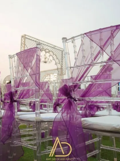 Elegant transparent chairs are dressed up with purple fabric, adding a pop of color and sophistication to the guest seating.