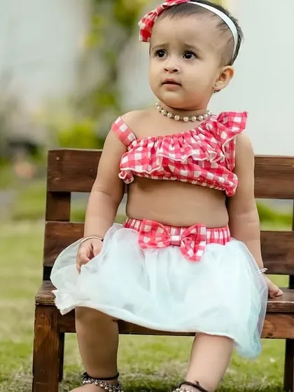 A sweet little girl sitting on a bench in our garden. The simple setup allows her natural beauty and personality to shine.