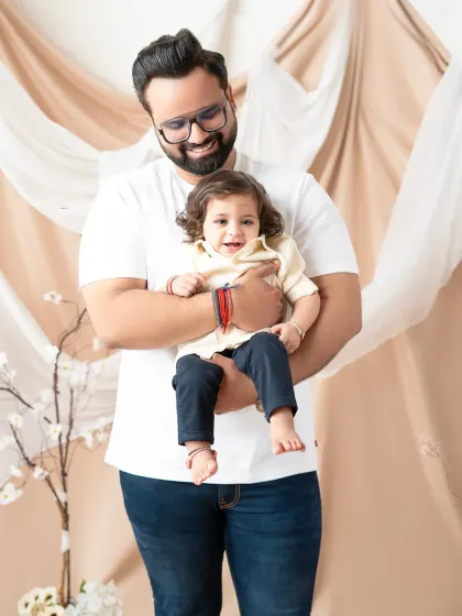 A father holds his smiling son in this heartwarming portrait. These photos celebrate the special bond between a dad and his child.