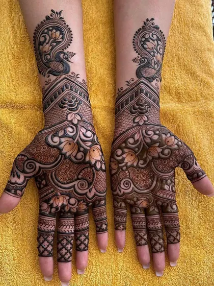 A grand bridal design featuring peacocks at the wrist and intricate floral and paisley patterns covering the palms. This is a perfect choice for a bride who wants a traditional and royal look.