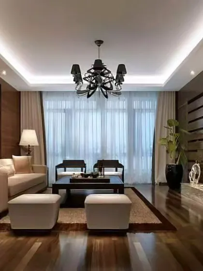 A luxurious living room design featuring rich wood paneling, a mirrored accent wall, and carefully selected lighting to create a sophisticated atmosphere.