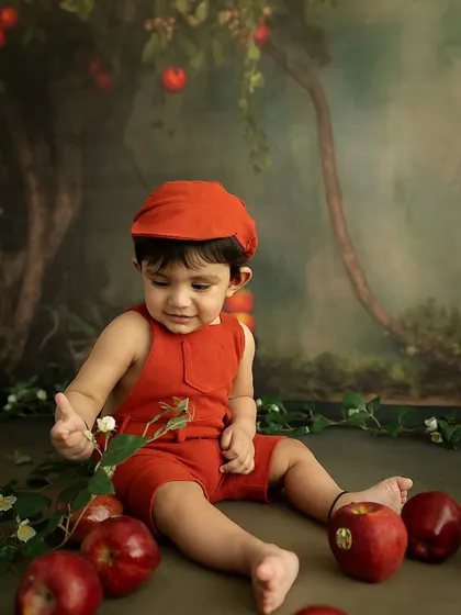 Examining a flower. This candid shot captures a moment of quiet curiosity during our playful apple-themed session.