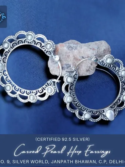 These carved pearl hoop earrings offer a unique twist on the classic hoop. The outer edge is scalloped and studded with small pearls, adding a touch of ethnic grace.