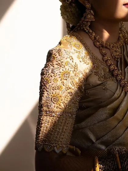 A close-up on the details. This shot showcases the intricate embroidery of the blouse and the flawless application of makeup on the bride's skin, creating a cohesive and elegant look.