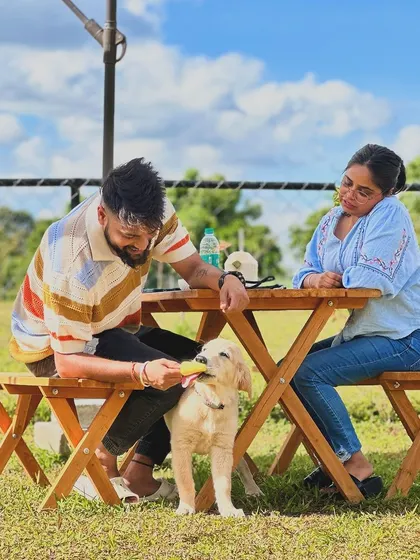 A couple sharing a sweet moment with their pup while enjoying a treat from our cafe.