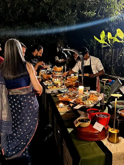 Guests enjoying the buffet at an outdoor event in Hampi. The spread is designed to complement the beautiful, rustic surroundings.