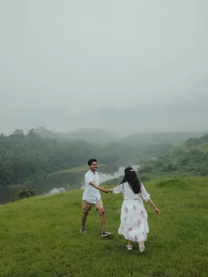 A candid moment of the couple walking hand-in-hand through the misty, rolling hills, creating a sense of journey and togetherness.