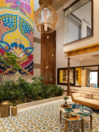 I collaborated with a team of artists and furniture designers for the Ashraya Residence to craft a home rooted in Indian identity. This view of the courtyard showcases the fusion of traditional elements, like the patterned floor tiles and tufted sofa, with contemporary design.