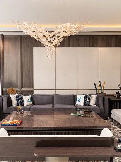 A full view of the living room, where layers of design come alive. The Koto wood paneling, wallpaper screen, and custom furniture create a space that is both warm and deeply sophisticated.