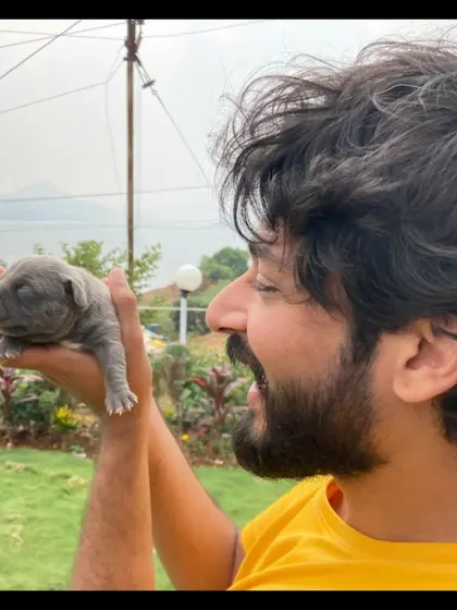 A fun moment holding a tiny newborn puppy. This shows my softer, playful side and my love for animals.