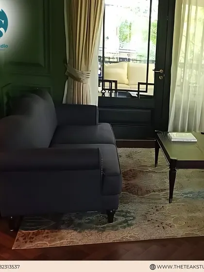 A classic dark grey two-seater sofa placed in a cozy corner. Its simple, timeless design and comfortable form make it a perfect addition to a reading nook or a smaller living area.
