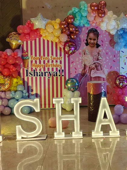A close-up of the Candyland birthday setup, highlighting the details of the balloon arch and custom props.