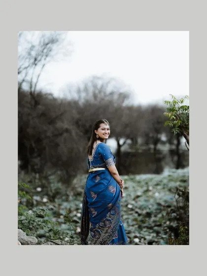 The bride looks back over her shoulder with a happy smile, a beautiful candid moment from her outdoor portrait session.